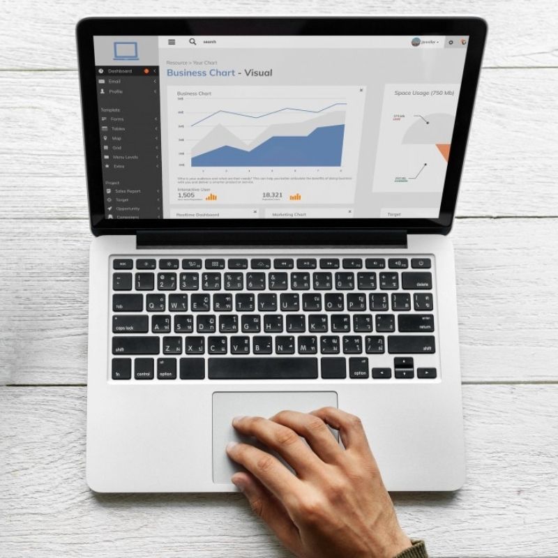 Panel de analítica SEO mostrando crecimiento de tráfico y posicionamiento web en laptop